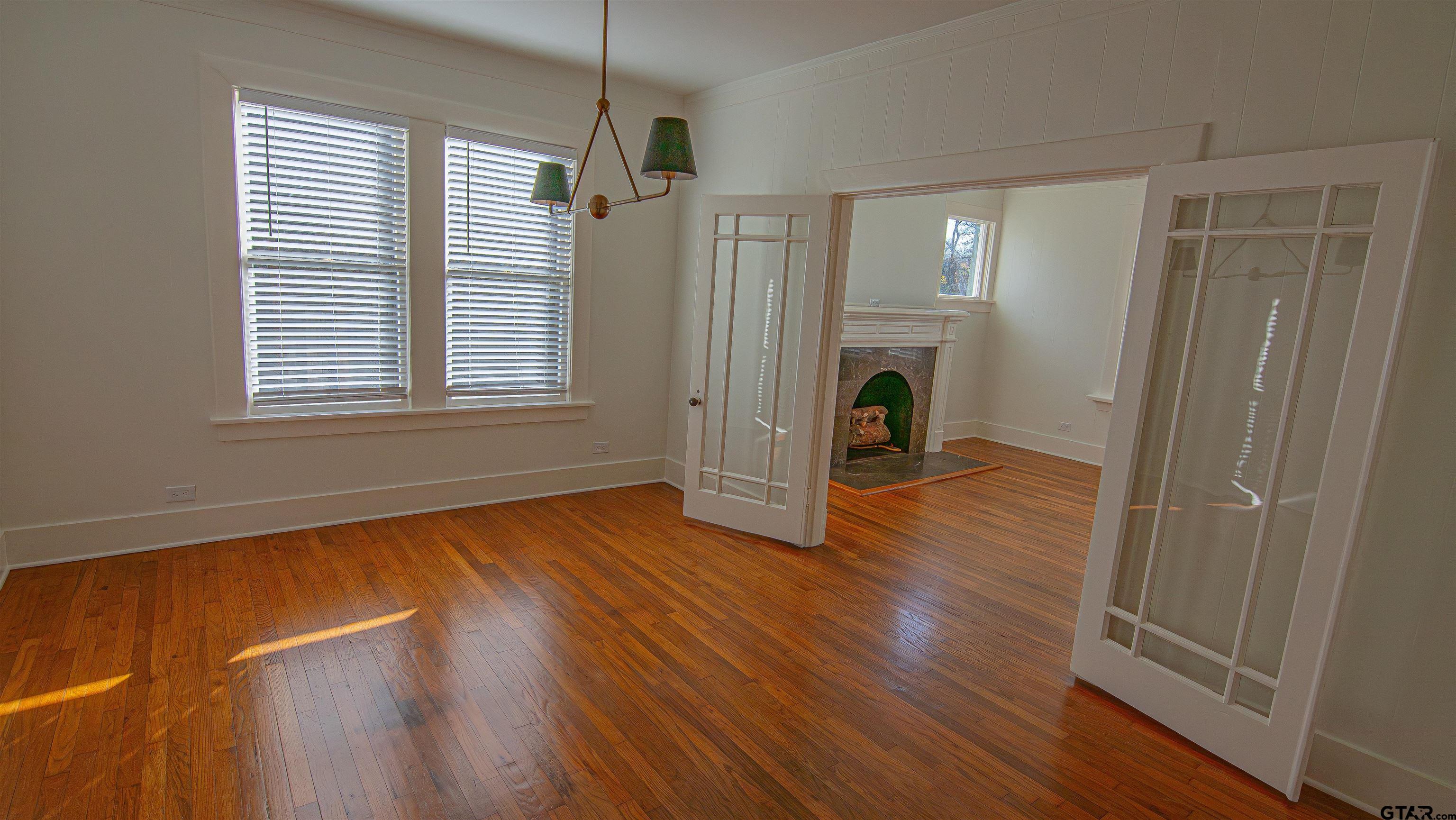 820 South Chilton Avenue Tyler, TX 75701 - Photo 3 of 20 a view of empty room with wooden floor fireplace and windows