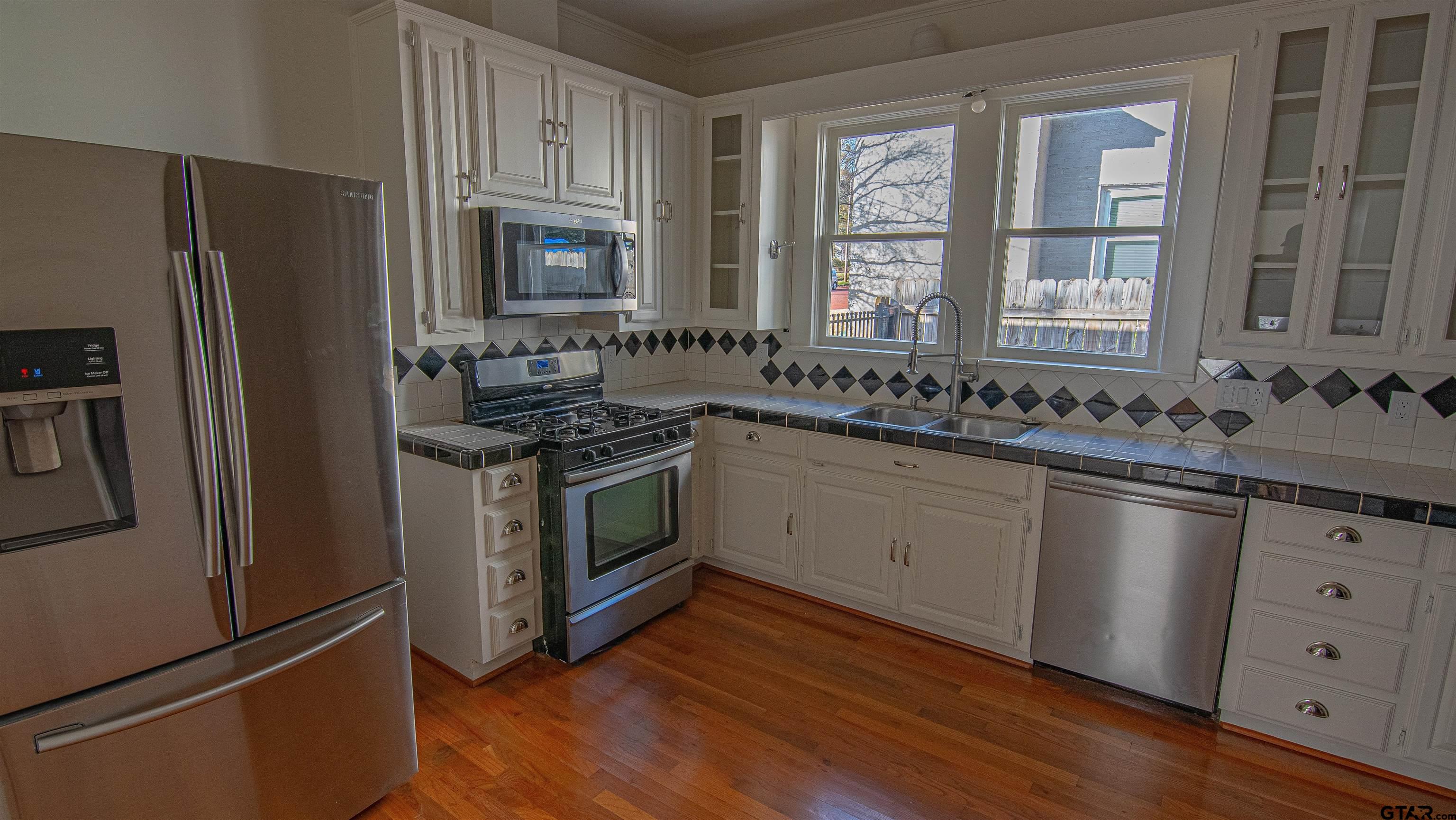 820 South Chilton Avenue Tyler, TX 75701 - Photo 8 of 20 a kitchen with a sink stove and refrigerator