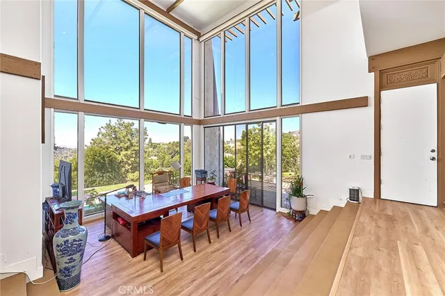 a kitchen with stainless steel appliances granite countertop a dining table chairs refrigerator and microwave