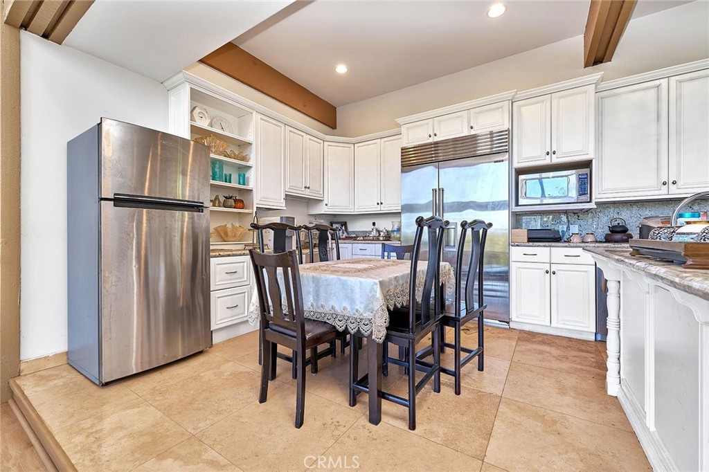 22702 Timbertop Lane Diamond Bar, CA 91765 - Photo 18 of 75 a kitchen with stainless steel appliances granite countertop a dining table chairs refrigerator and microwave