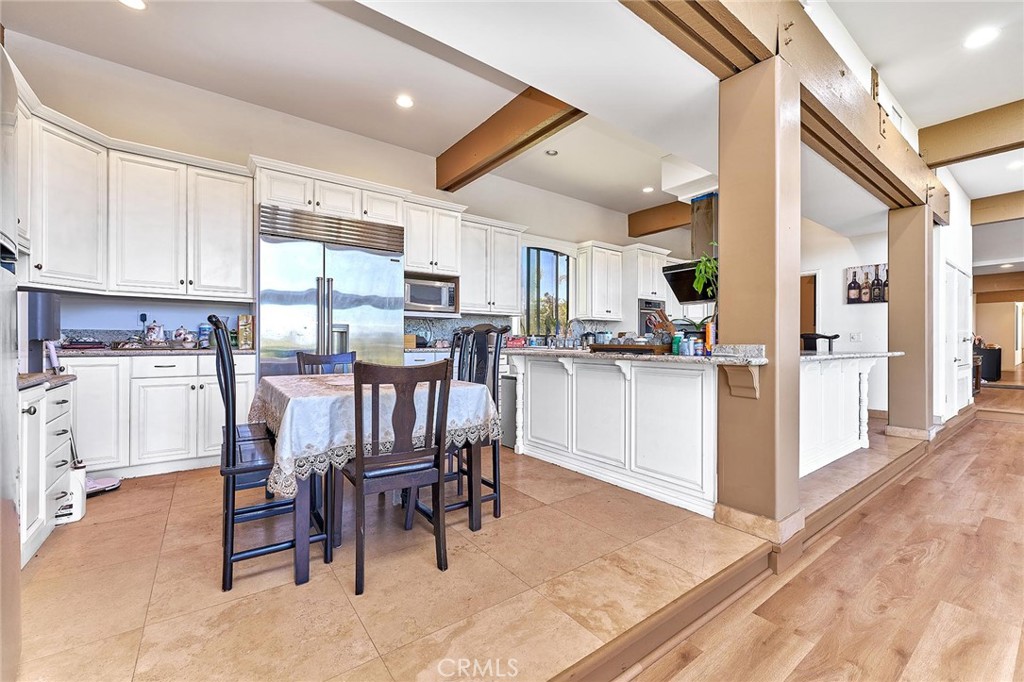 22702 Timbertop Lane Diamond Bar, CA 91765 - Photo 19 of 75 a kitchen with stainless steel appliances kitchen island granite countertop a table chairs sink and cabinets