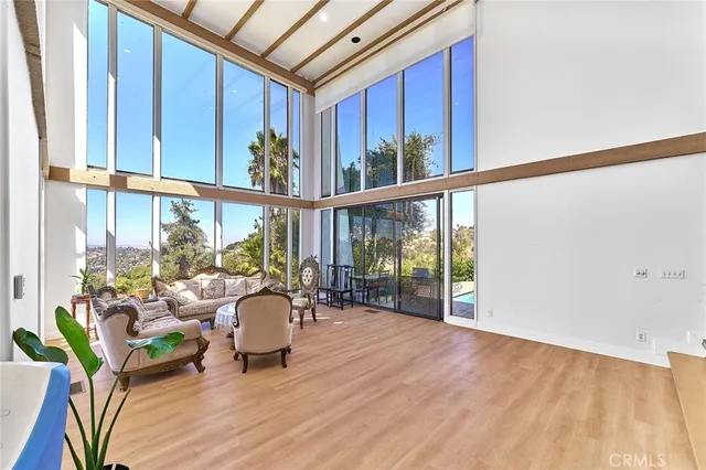 a living room with furniture floor to ceiling window and wooden floor