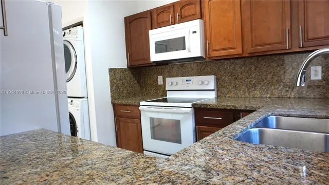a kitchen with stainless steel appliances granite countertop a refrigerator stove and sink