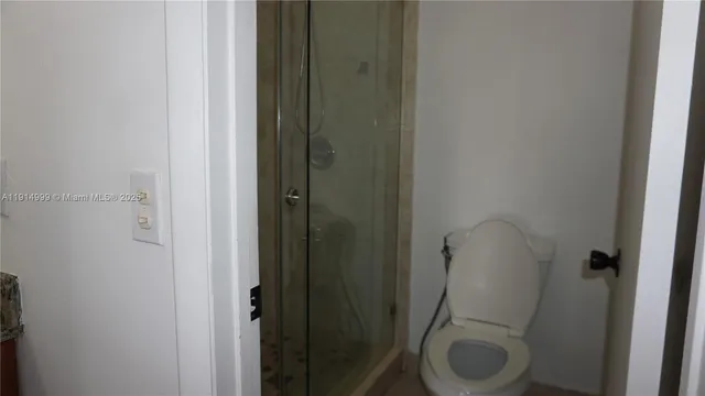 a bathroom with a granite countertop toilet and a sink