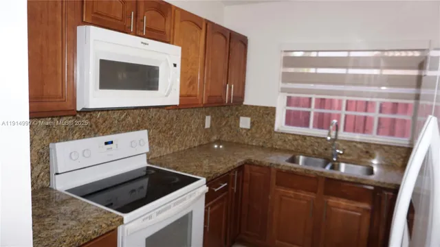 a kitchen with a sink stove and microwave