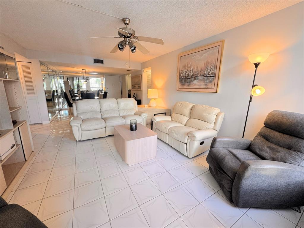 7950 West McNab Road, Unit 203 Tamarac, FL 33321 - Photo 7 of 21 a living room with furniture and a flat screen tv
