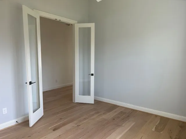 a view of an empty room with wooden floor