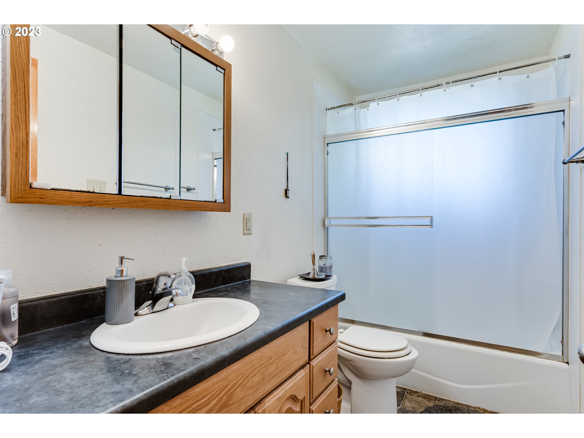 1400 I Street Springfield, OR 97477 - Photo 11 of 16 a bathroom with a granite countertop sink toilet a mirror and shower
