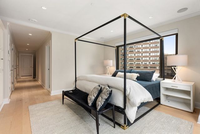 a bedroom with a bed and a couch next to a window