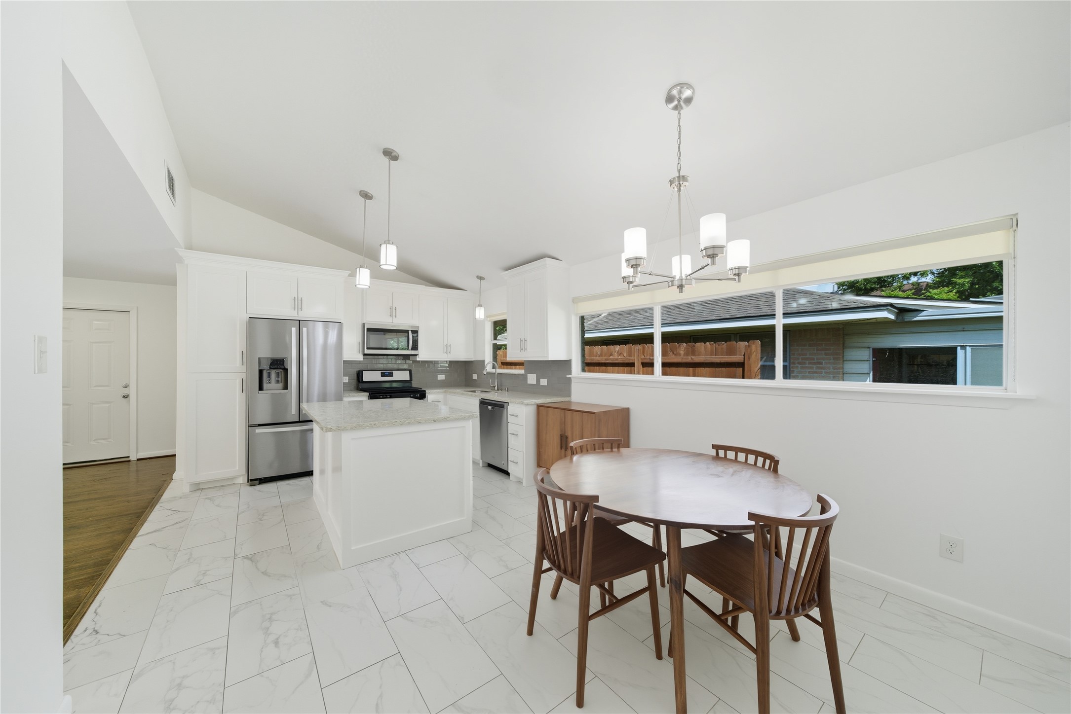 11223 Greenwillow Street Houston, TX 77035 - Photo 11 of 29 a kitchen with kitchen island a dining table chairs stainless steel appliances and cabinets