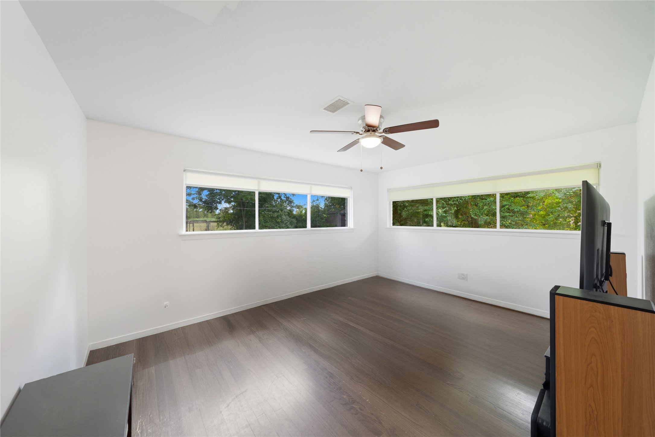 11223 Greenwillow Street Houston, TX 77035 - Photo 13 of 29 an empty room with wooden floor fan and windows