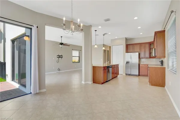 a view of a kitchen with refrigerator and wooden floor