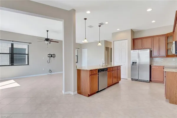 a large kitchen with stainless steel appliances a refrigerator and a stove top oven