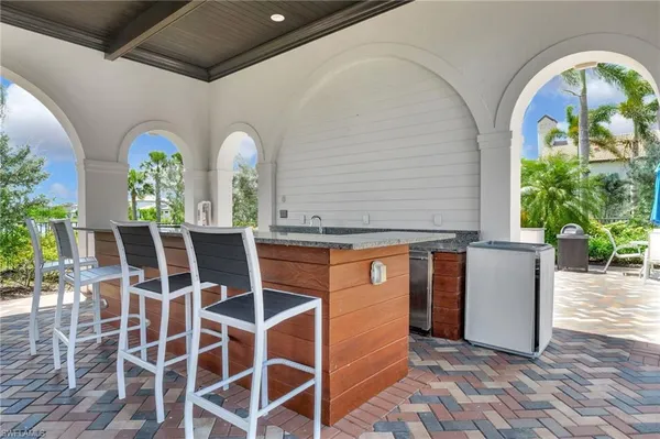 a white house with a small yard and palm trees