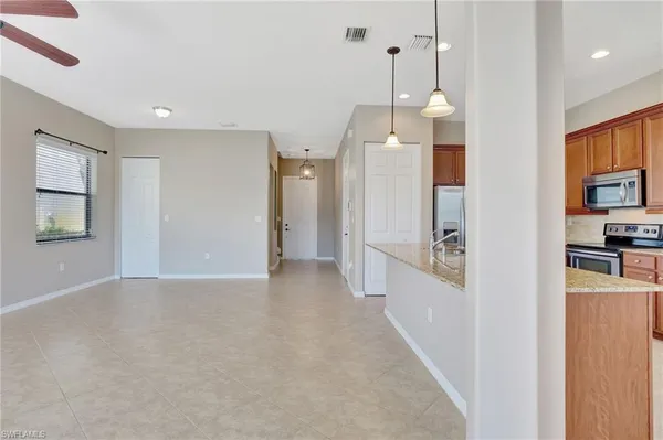 a view of a kitchen with refrigerator and wooden floor