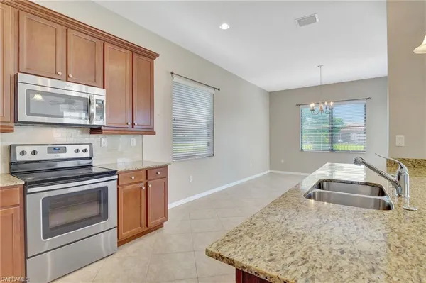 a kitchen with kitchen island granite countertop a stove sink and microwave
