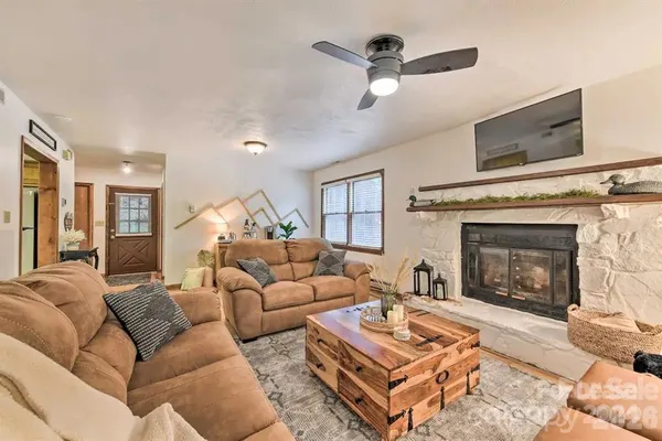 a living room with furniture a fireplace and a flat screen tv
