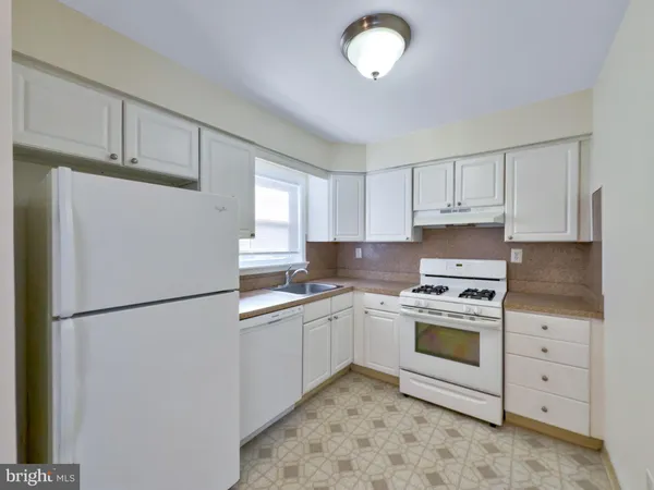 a kitchen with a stove a refrigerator and a sink