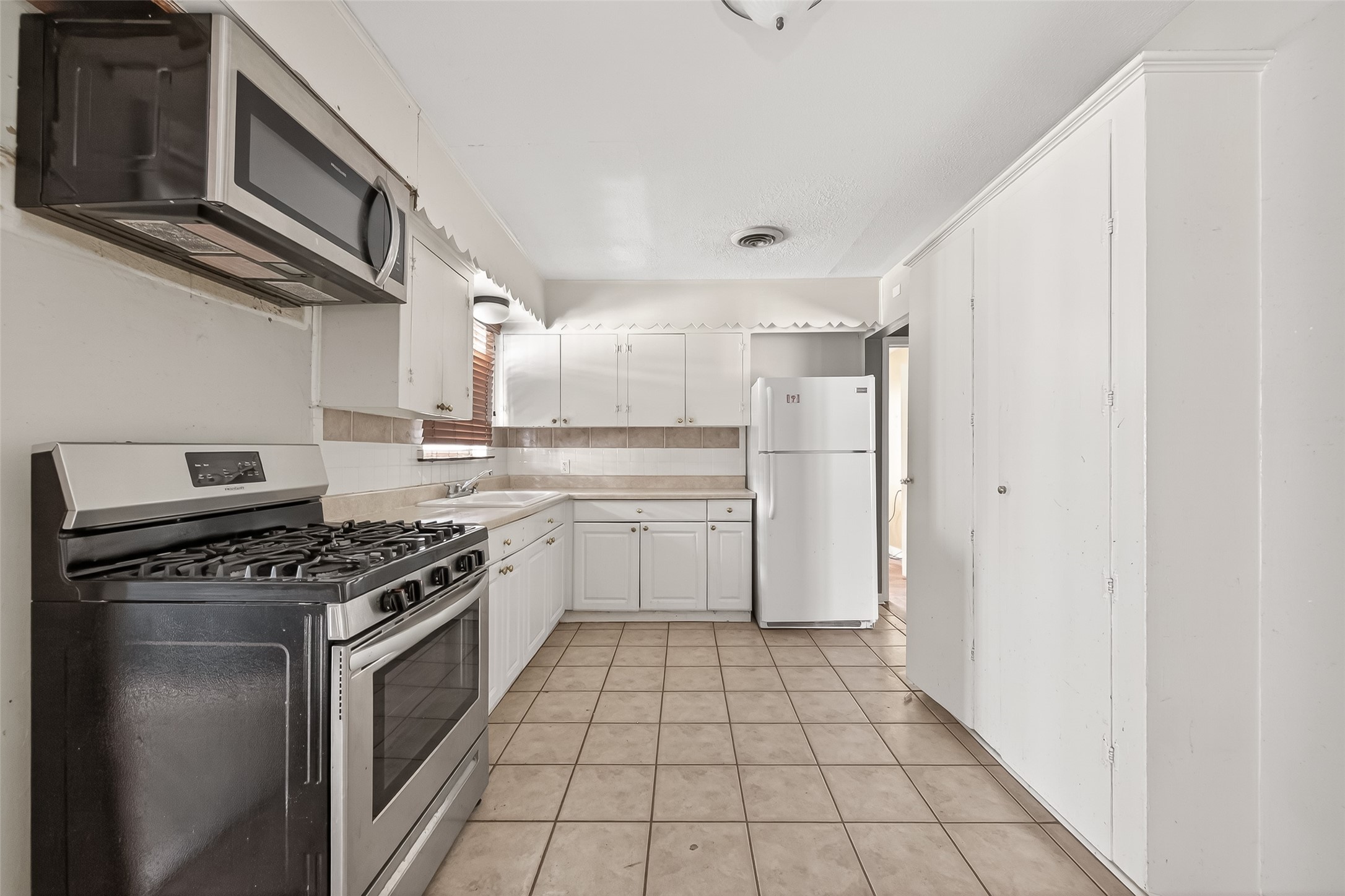 5114 West 43rd Street Houston, TX 77092 - Photo 17 of 31 a kitchen with a stove top oven and cabinets