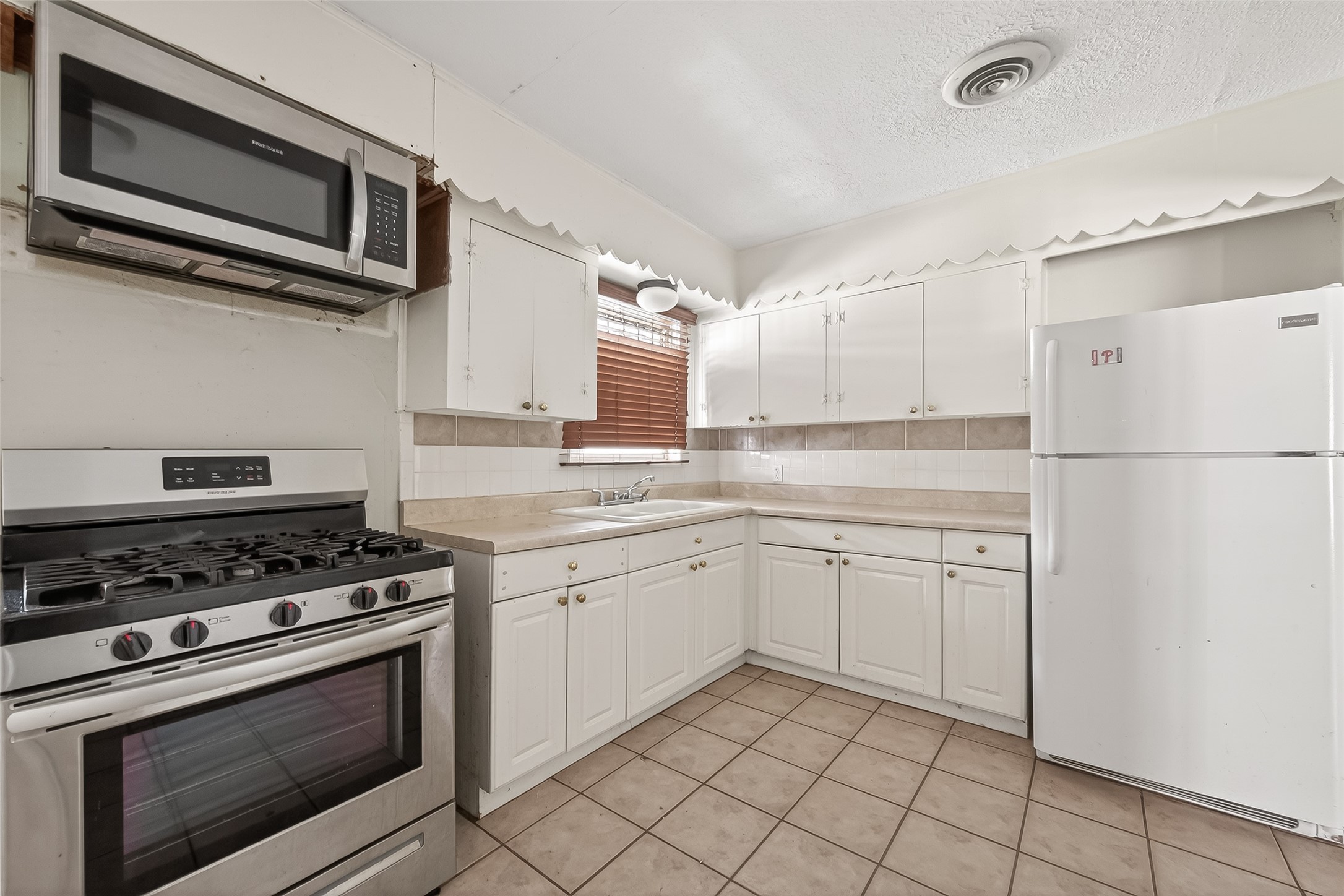 5114 West 43rd Street Houston, TX 77092 - Photo 18 of 31 a kitchen with cabinets stainless steel appliances and a sink