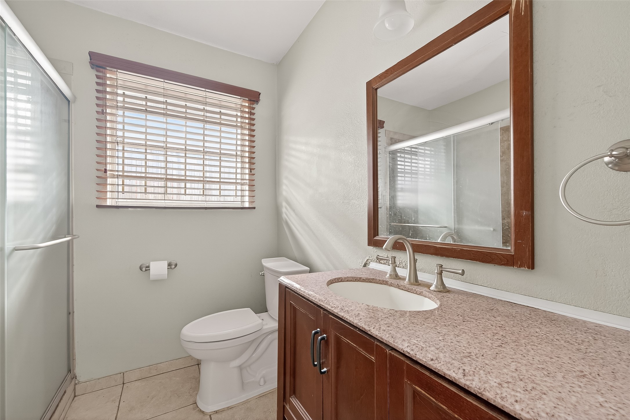 5114 West 43rd Street Houston, TX 77092 - Photo 23 of 31 a bathroom with a granite countertop sink toilet and mirror