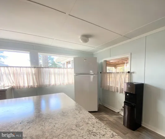 a view of a hallway with wooden floor and cabinet