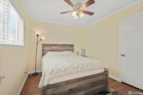 a bed sitting in a bedroom next to a window and a chandelier