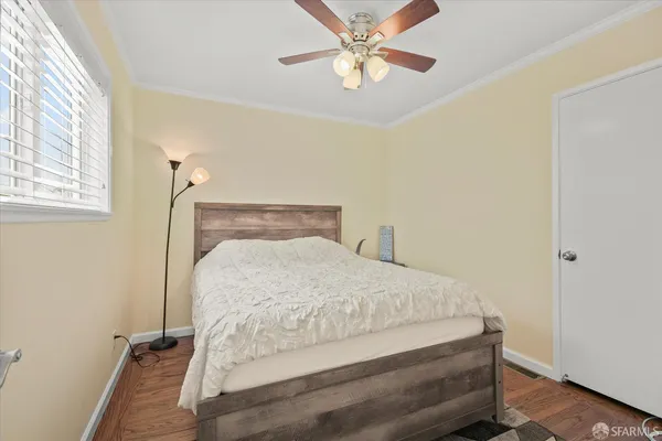 a bed sitting in a bedroom next to a window and a chandelier