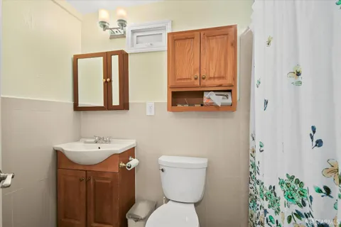 a bathroom with a toilet a sink and mirror