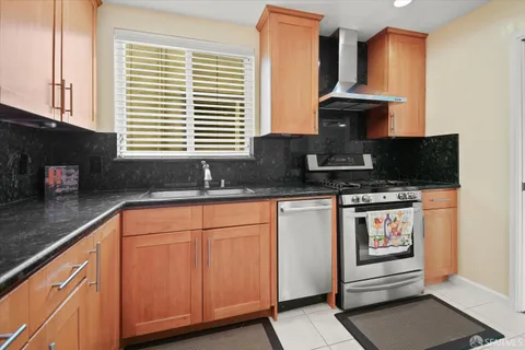 a kitchen with granite countertop a sink stove and cabinets