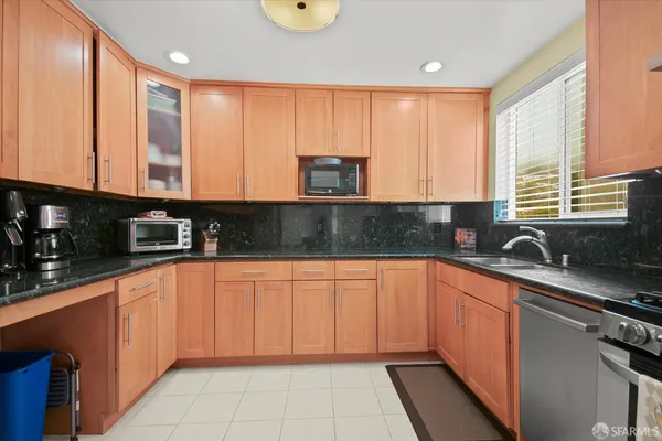 a kitchen with stainless steel appliances granite countertop a sink a stove and cabinets