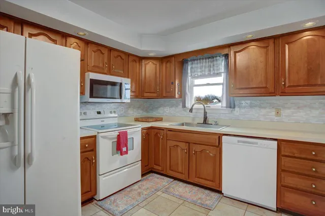 a kitchen with stainless steel appliances granite countertop a sink stove refrigerator and cabinets