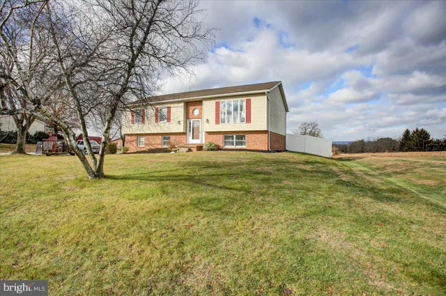 a view of a house with a big yard and large trees