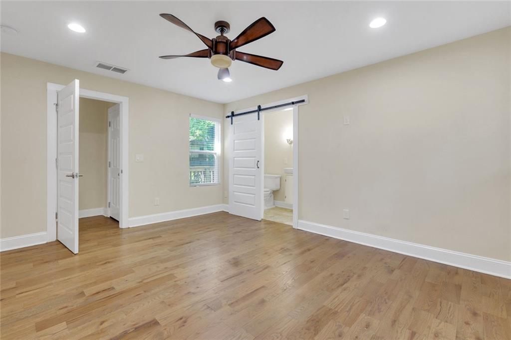 998 Mayson Turner Road Northwest, Unit A Atlanta, GA 30314 - Photo 13 of 26 an empty room with wooden floor and windows