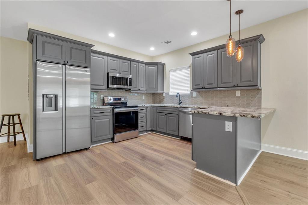 998 Mayson Turner Road Northwest, Unit A Atlanta, GA 30314 - Photo 8 of 26 a kitchen with stainless steel appliances granite countertop a refrigerator a sink a stove a microwave and island