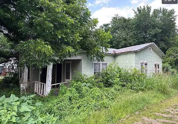 a view of a house with a yard and potted plants