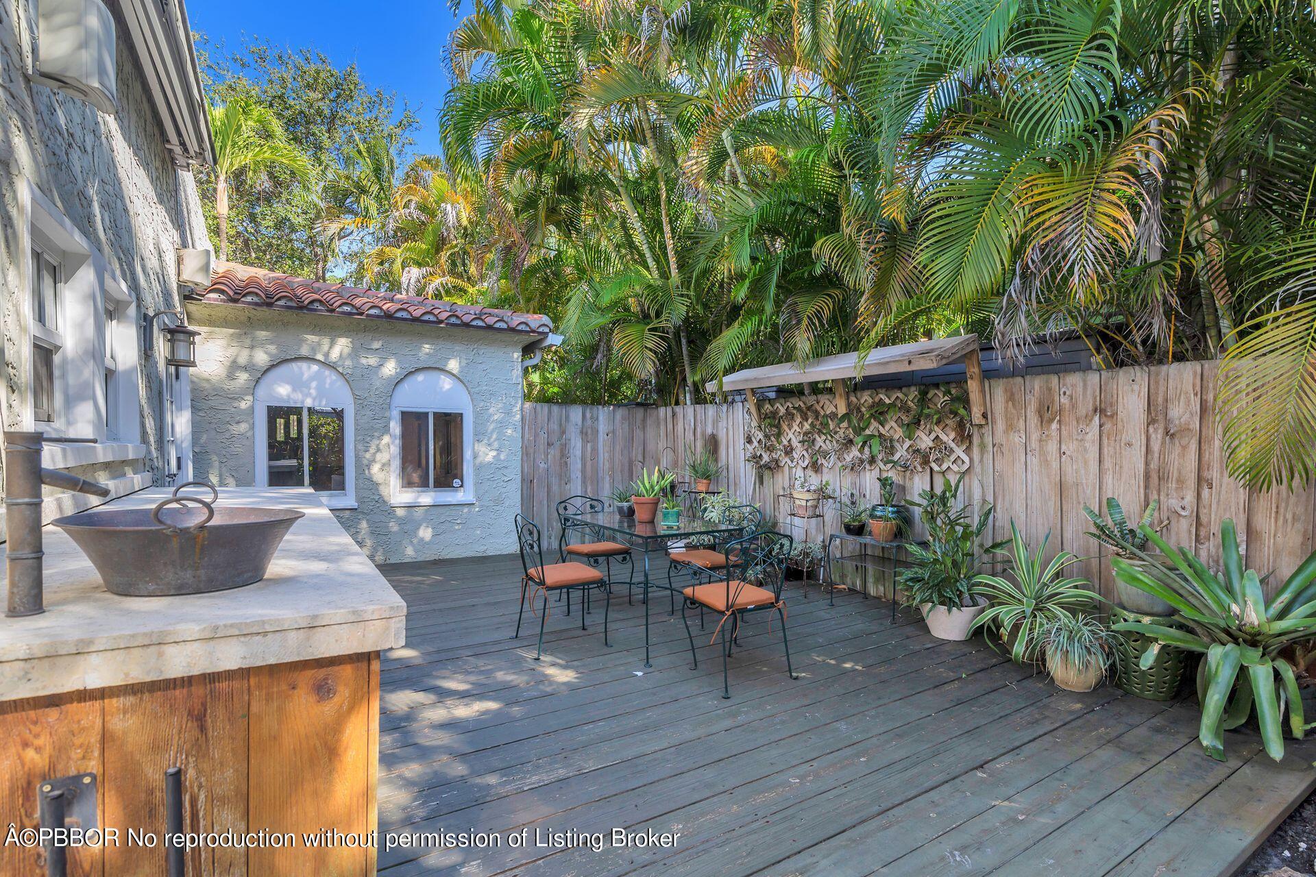 810 Avon Road West Palm Beach, FL 33401 - Photo 17 of 23 a view of a patio with table and chairs potted plants and wooden fence