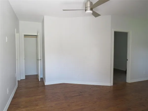 a view of an empty room with closet and a window