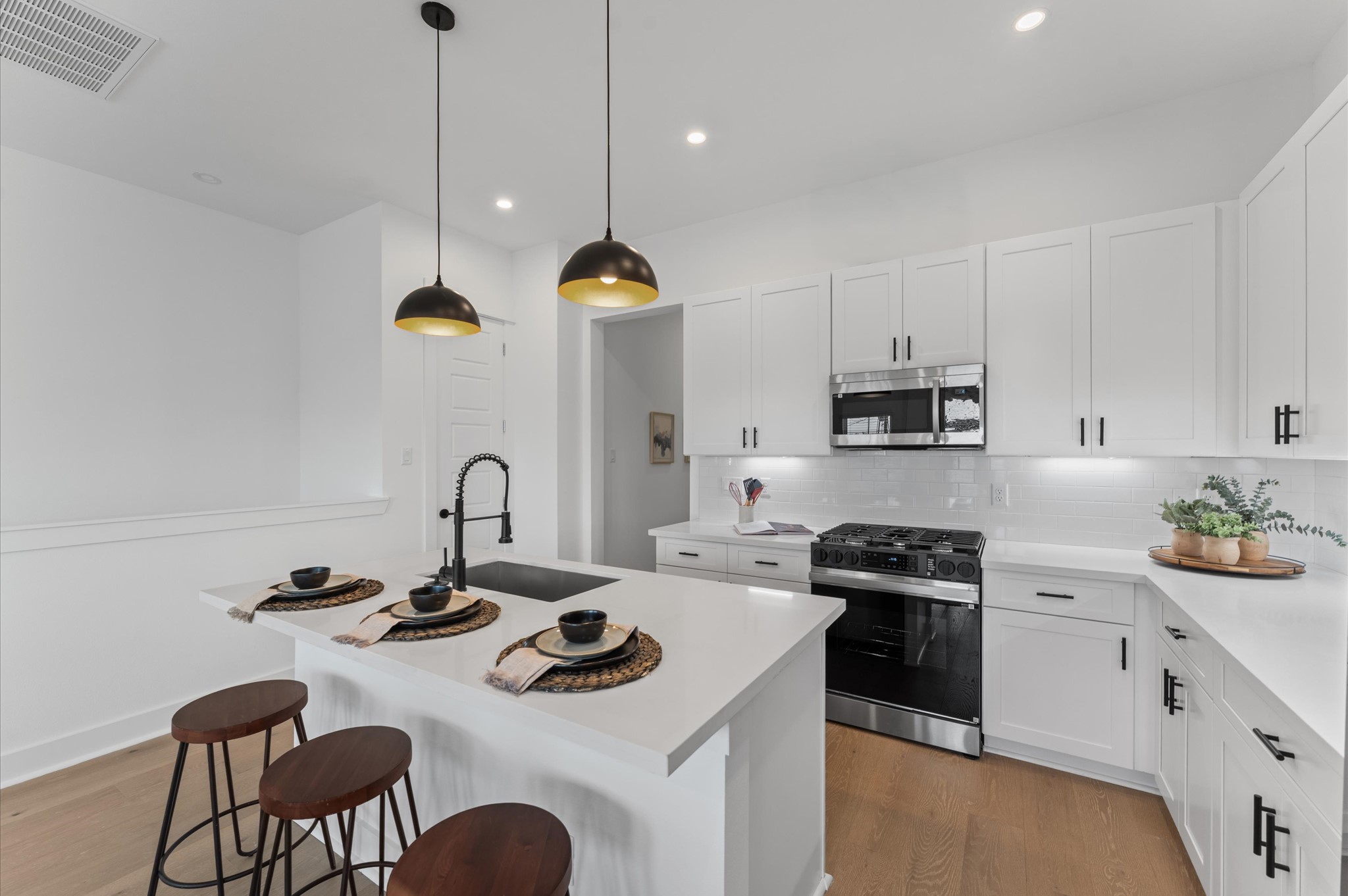 2710 Jensen Drive Houston, TX 77026 - Photo 13 of 38 This centrally positioned kitchen island serves as a stylish anchor within the open-concept layout, offering clear sightlines to the dining area, living space, and the balcony beyond. Its placement encourages seamless interaction, whether prepping meals or entertaining guests, while natural light pours in through the nearby French doors. The island’s sleek design and functional surface make it a hub of activity tying together comfort and sophistication.