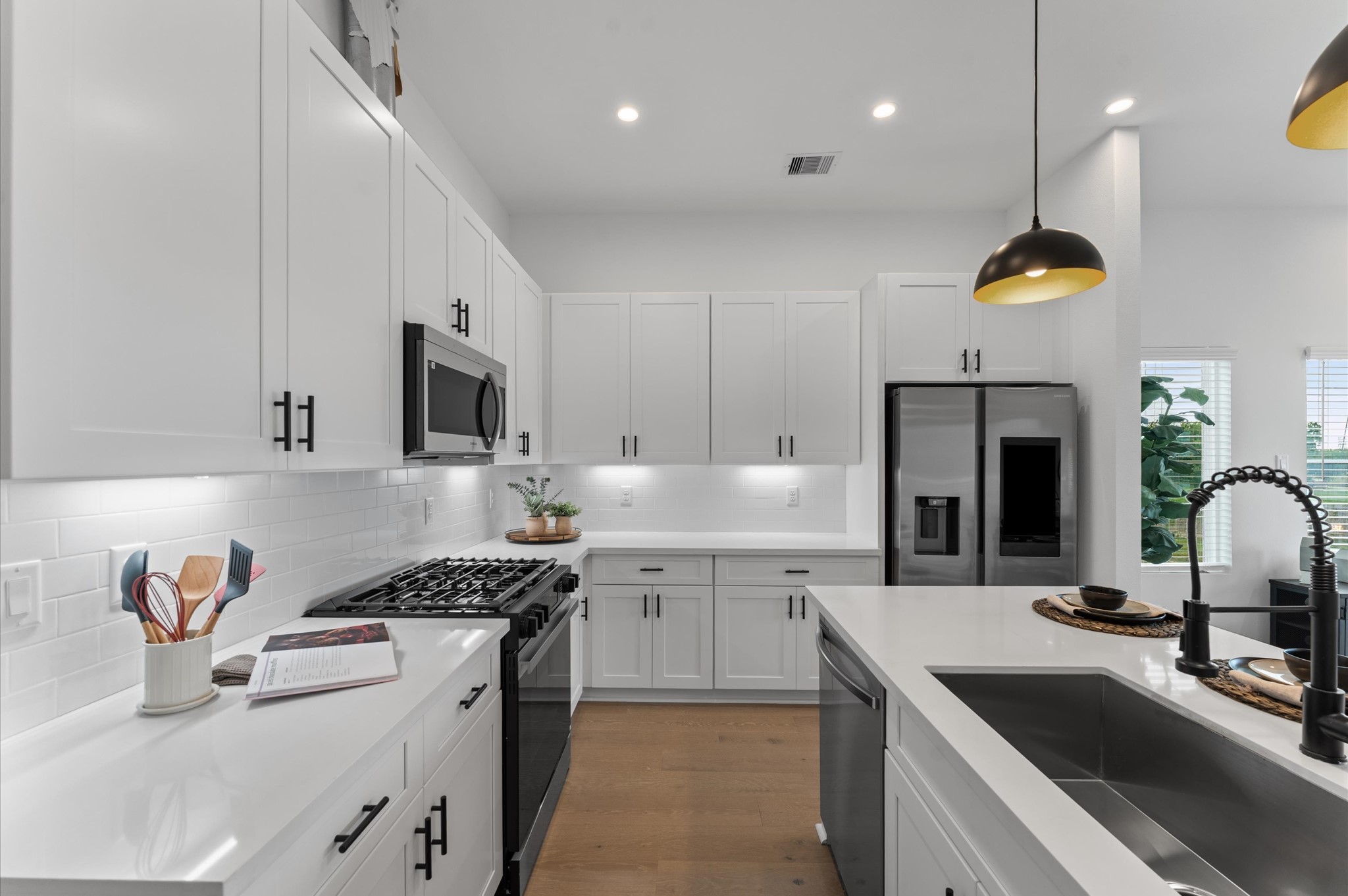 2710 Jensen Drive Houston, TX 77026 - Photo 14 of 38 This modern kitchen is a masterclass in both style and functionality, featuring abundant cabinetry along the walls and a spacious island with built-in storage. The cabinetry offers generous room for cookware, pantry items, and small appliances, while the island includes drawers and cabinets that maximize organization and prep space. Sleek stainless-steel appliances, blend seamlessly into the design, enhancing the kitchen’s polished aesthetic.