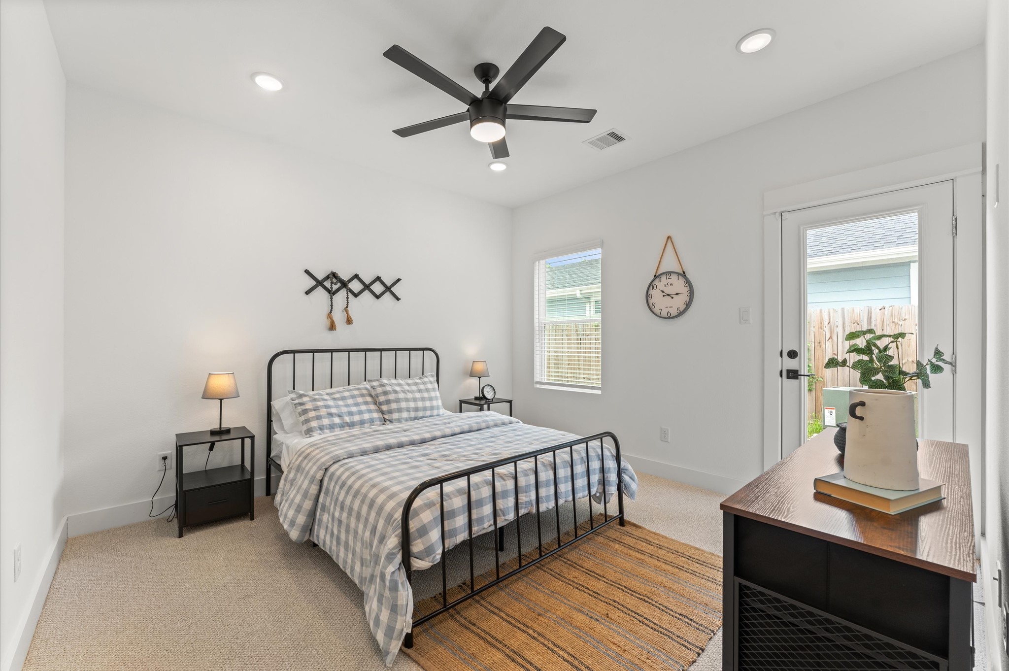 2710 Jensen Drive Houston, TX 77026 - Photo 18 of 38 Stylish and versatile secondary bedroom situated on the first floor, offering direct access to the backyard through elegant glass patio door. This sunlit space features warm-toned flooring, soft neutral walls, and generous room for a queen-sized bed and additional furnishings. Outdoor access enhances the room’s appeal for relaxation, remote work, guest room.