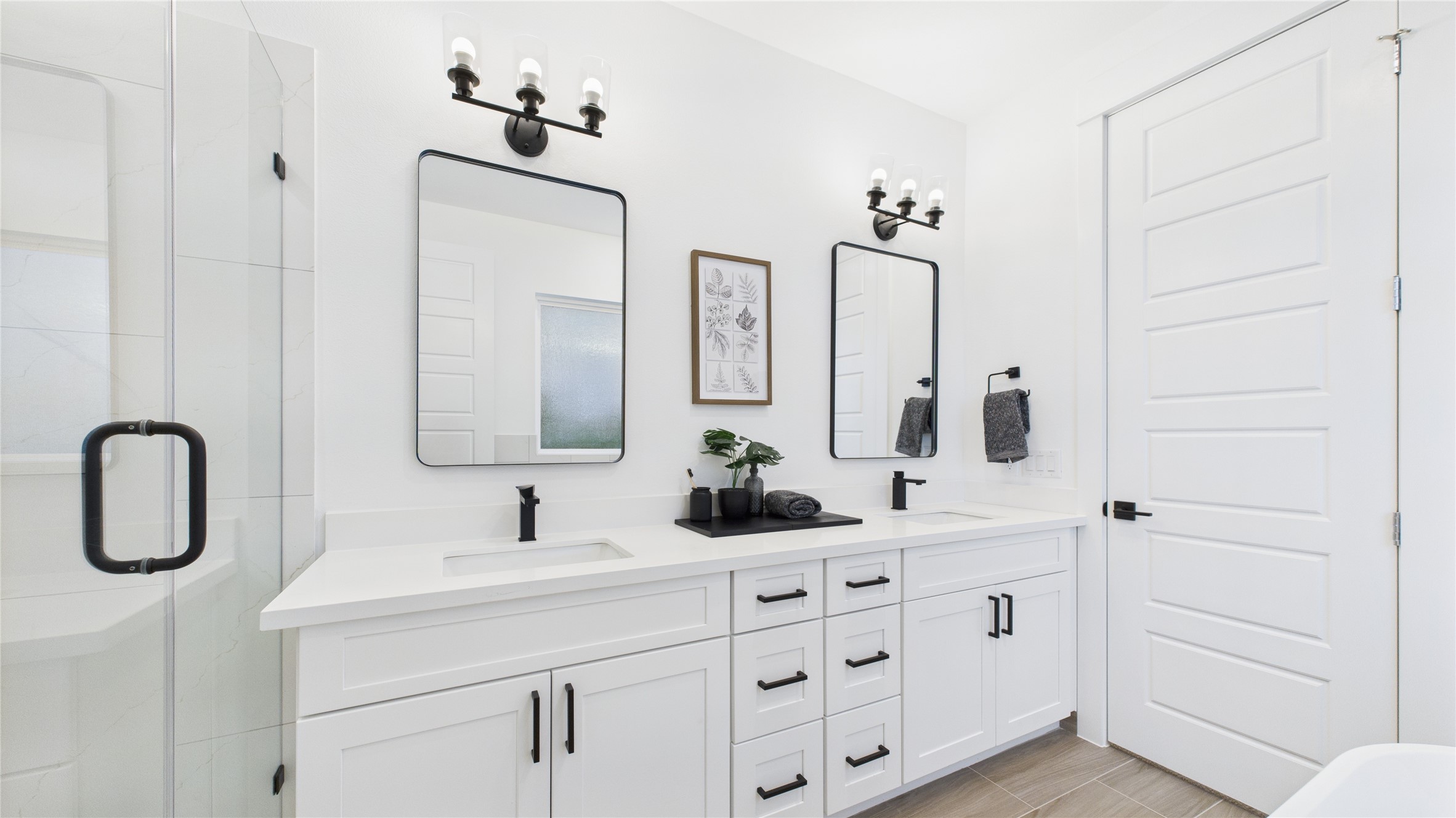 2710 Jensen Drive Houston, TX 77026 - Photo 24 of 38 This stylish primary bathroom showcases a spacious walk-in shower framed with sleek glass panels and modern tilework that adds texture and sophistication. A double sink vanity anchors the space with clean lines and ample countertop room, complemented by an abundance of cabinetry that offers both function and flair. Contemporary finishes tie the room together, creating a polished retreat that balances luxury with everyday practicality.