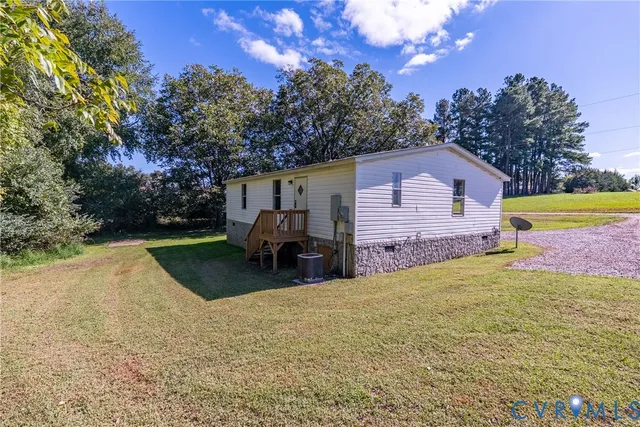 a view of a house with backyard and a tree