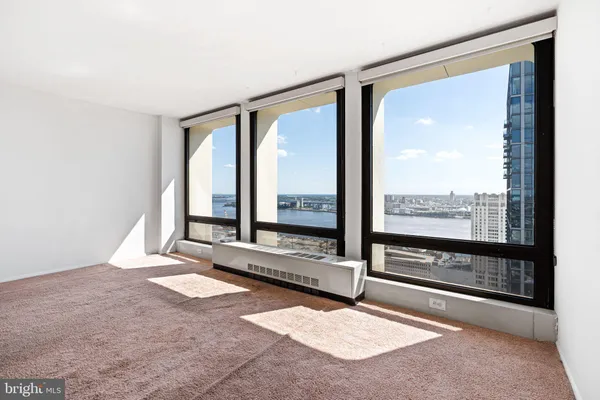 a living room with a large window and a rug