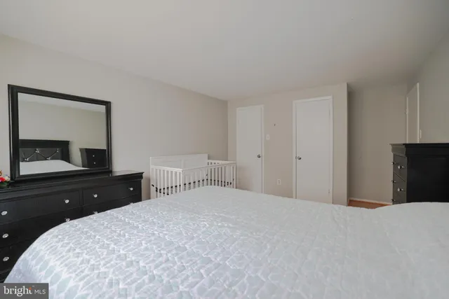 a bedroom with a bed and a dresser with mirror