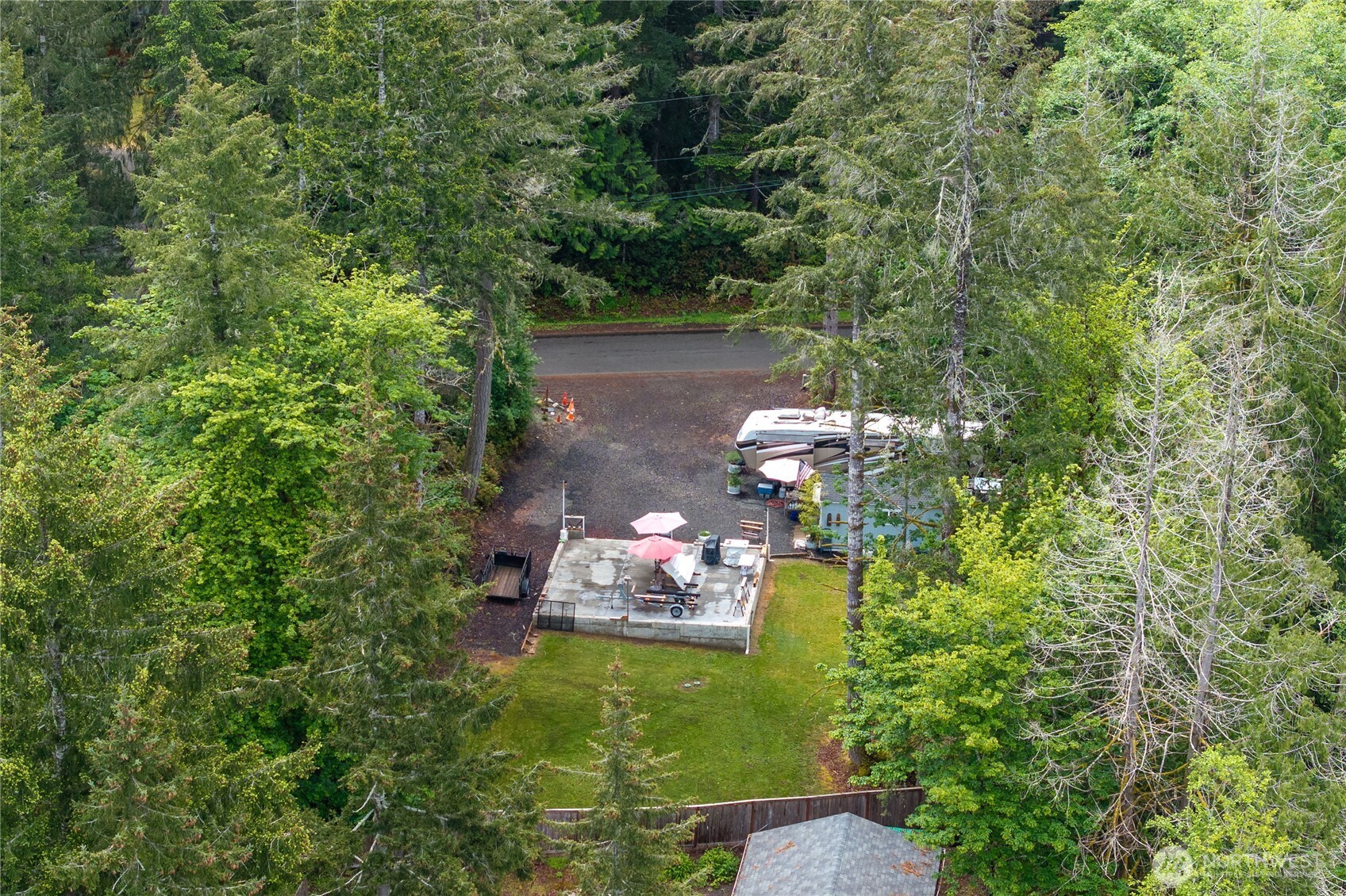 151 East Hillside Drive Belfair, WA 98528 - Photo 12 of 24 a backyard of a house with table and chairs potted plants and large tree