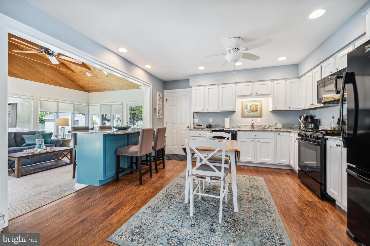 3 Oriole Drive Cambridge, MD 21613 - Photo 11 of 46 a kitchen with stainless steel appliances kitchen island granite countertop a table chairs sink and cabinets