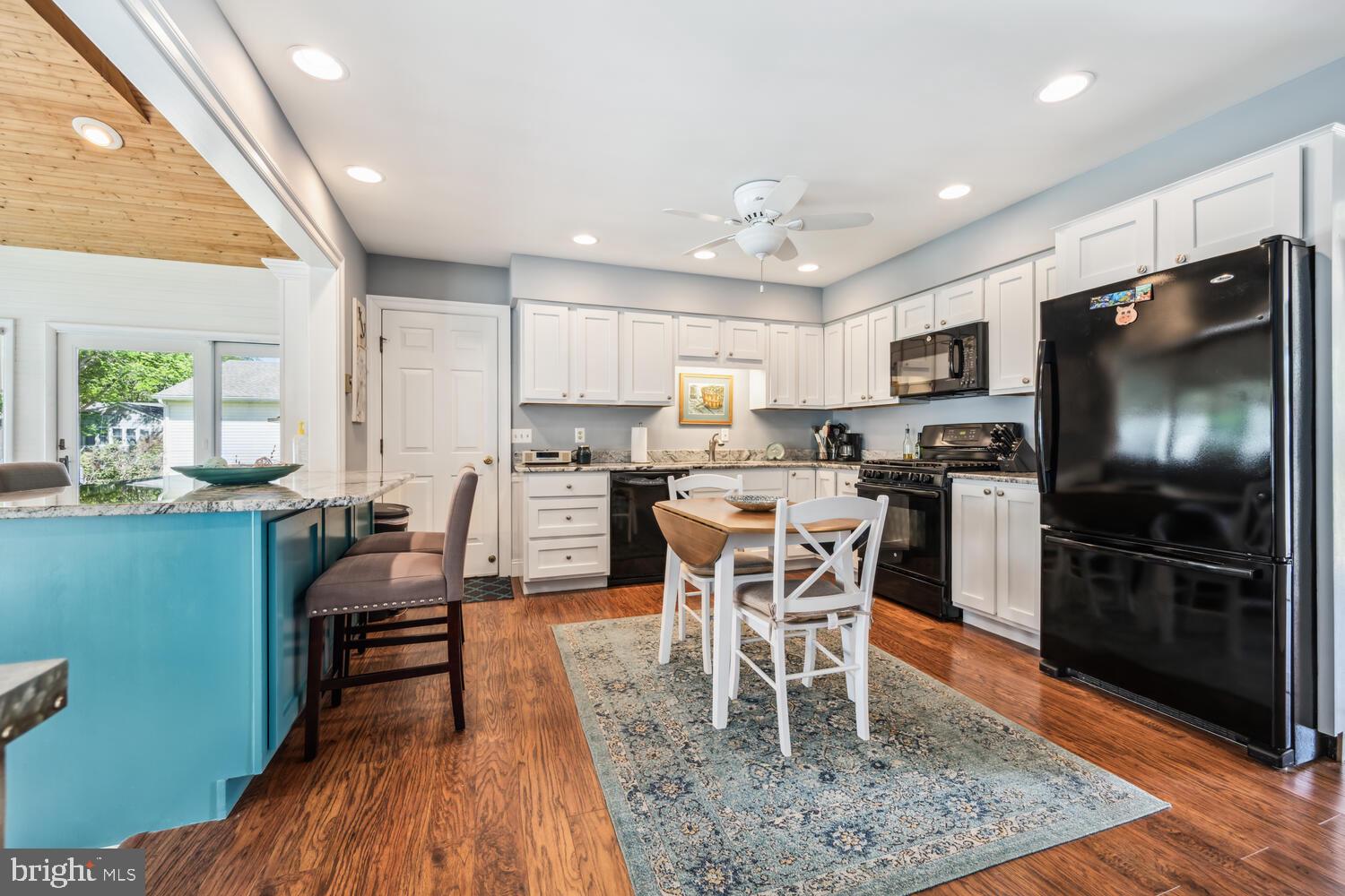 3 Oriole Drive Cambridge, MD 21613 - Photo 12 of 46 a kitchen with stainless steel appliances granite countertop a table chairs microwave and sink