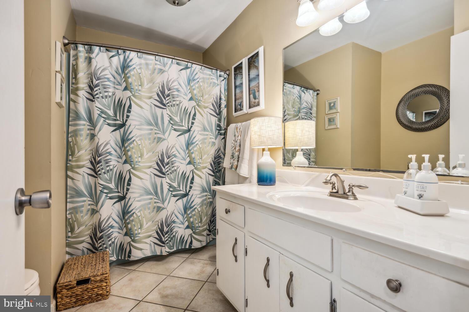 3 Oriole Drive Cambridge, MD 21613 - Photo 23 of 46 a bathroom with a granite countertop sink a mirror and shower curtain