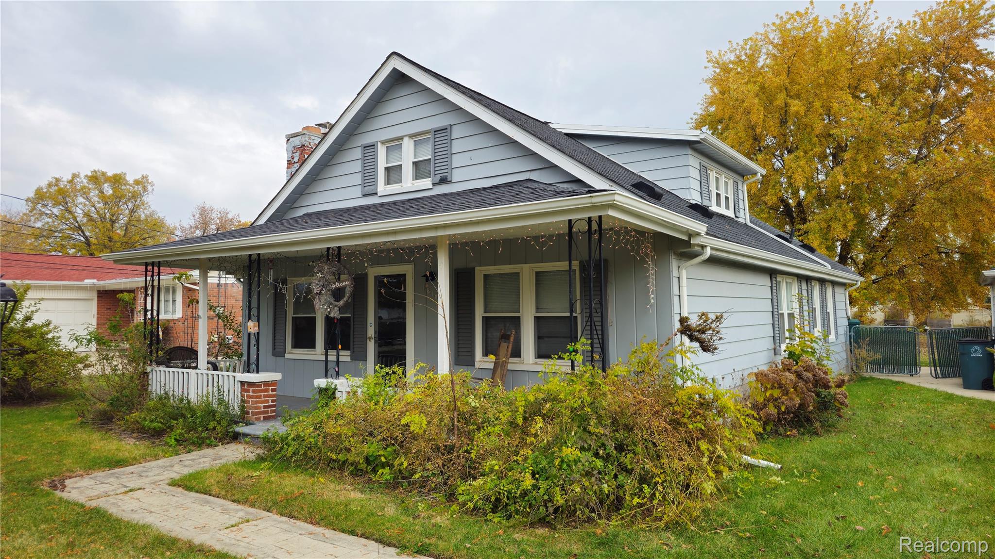 Bungalow-style home featuring a porch, a shingled roof, and a chimney